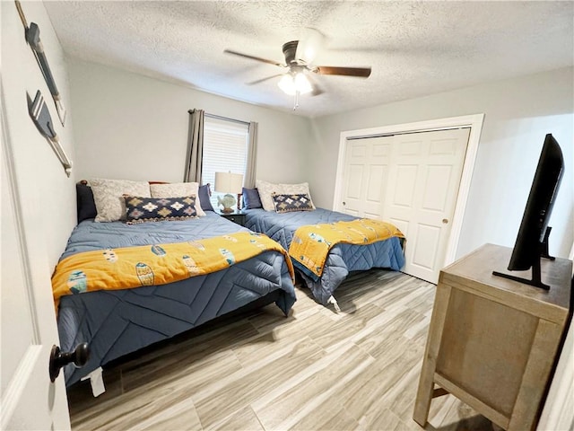9462 Riley Green Rd, Franklin, TX 77856 - bedroom featuring light wood-style flooring, a closet, a ceiling fan, and a textured ceiling