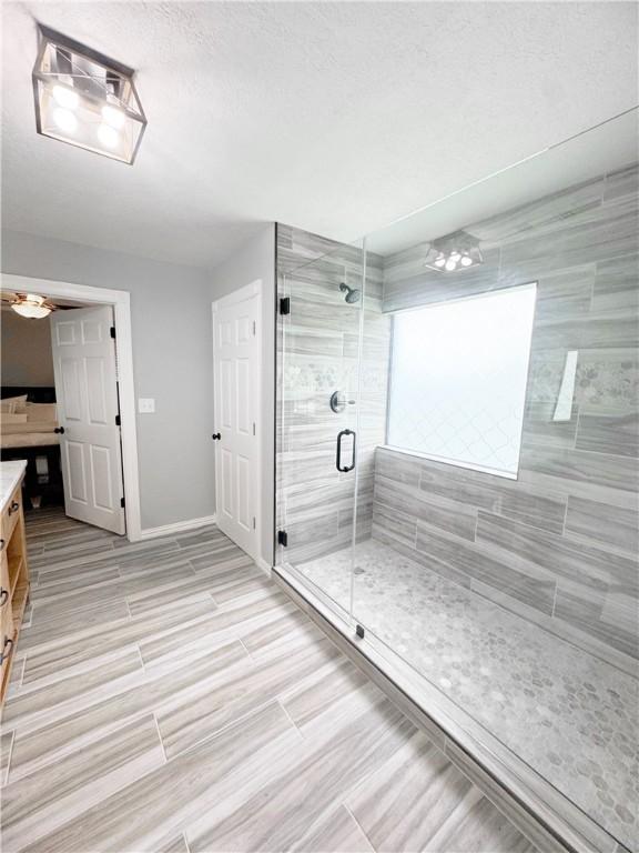 9462 Riley Green Rd, Franklin, TX 77856 - full bath featuring vanity, a stall shower, baseboards, and a textured ceiling