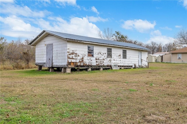 rear view of property featuring a lawn