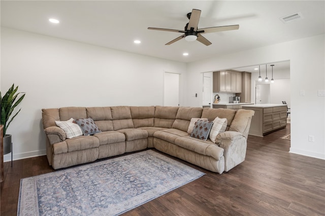 living room featuring ceiling fan and dark wood-type flooring