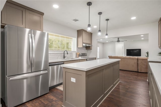 kitchen featuring a center island, dark wood-type flooring, stainless steel appliances, decorative backsplash, and ceiling fan