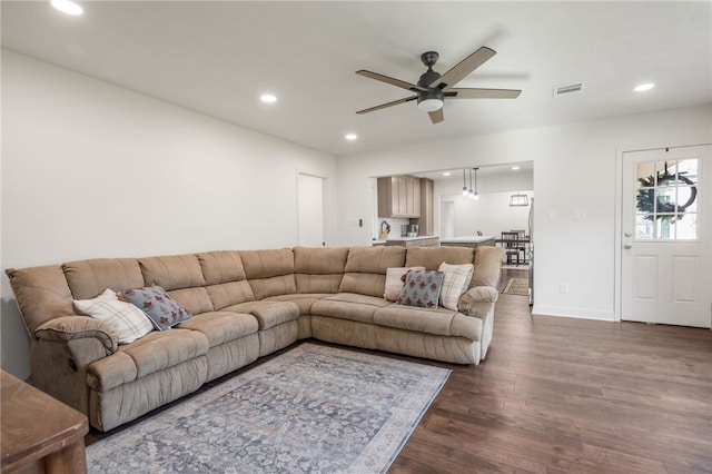 living room with ceiling fan and dark hardwood / wood-style flooring