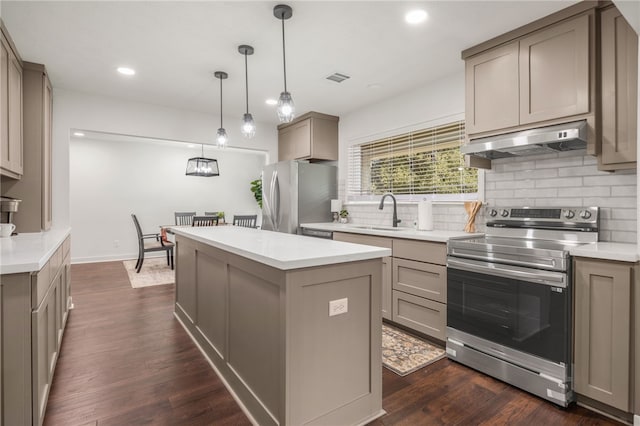 kitchen with appliances with stainless steel finishes, dark hardwood / wood-style flooring, a center island, and sink