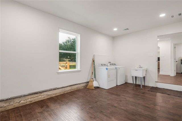 washroom with washer and dryer, dark hardwood / wood-style floors, and sink