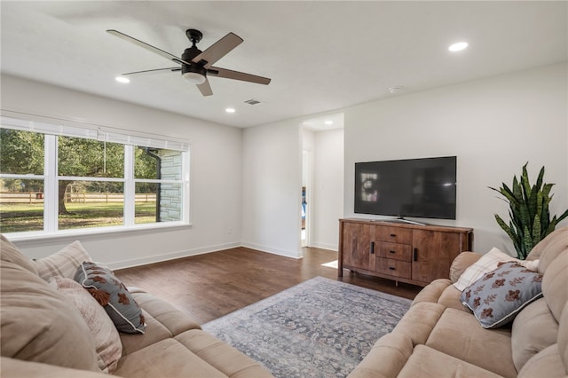 living room with dark wood-type flooring and ceiling fan