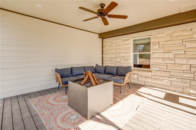 deck featuring ceiling fan and an outdoor living space with a fire pit