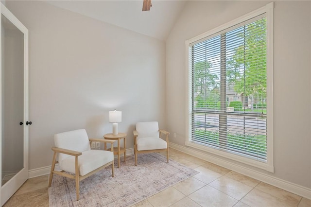 living area with tile patterned floors, plenty of natural light, baseboards, and vaulted ceiling