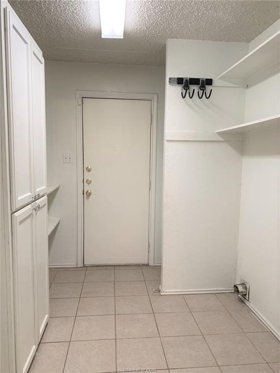 washroom with light tile patterned floors and a textured ceiling