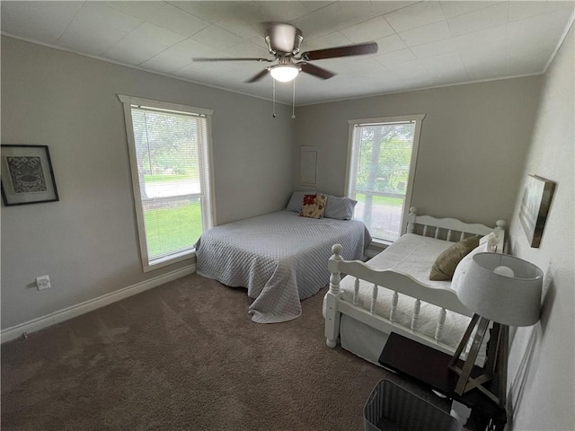 bedroom featuring ceiling fan, ornamental molding, and dark carpet