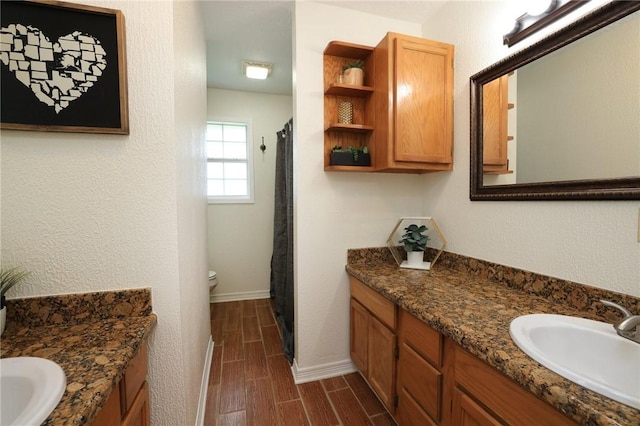 3000 Stevens Dr, Bryan, TX 77803 - full bath with wood tiled floors, vanity, baseboards, toilet, and a shower with shower curtain