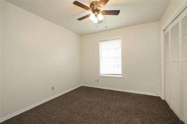 3000 Stevens Dr, Bryan, TX 77803 - unfurnished bedroom featuring a closet, dark carpet, baseboards, and a ceiling fan