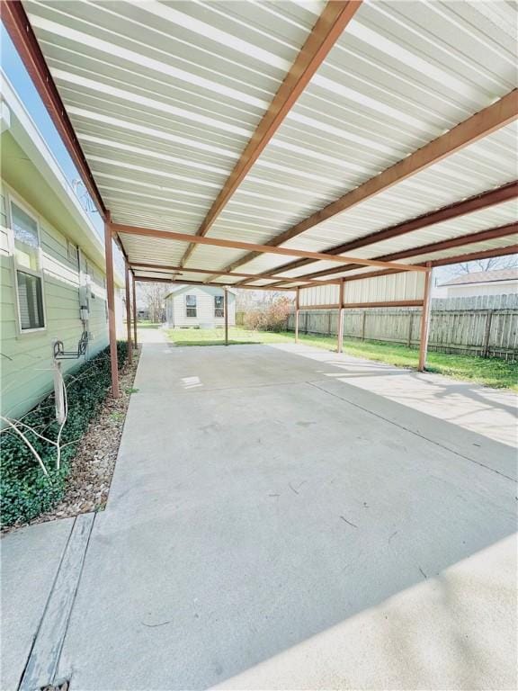 interior space with a storage shed, fence, and a carport