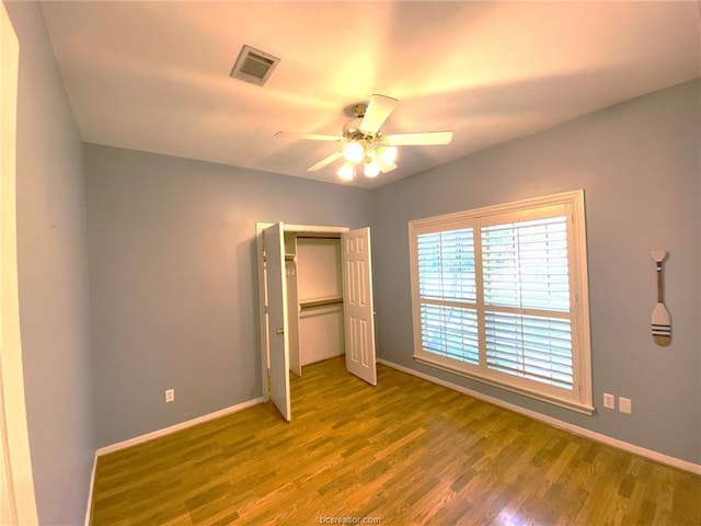 1608 Panther Ln, College Station, TX 77840 - unfurnished bedroom with wood finished floors, baseboards, a closet, and a ceiling fan