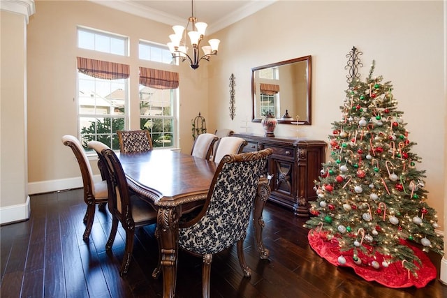 dining room with dark hardwood / wood-style flooring, crown molding, and an inviting chandelier