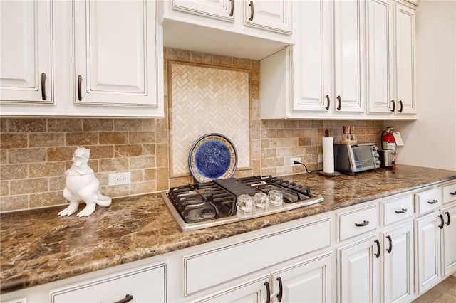 kitchen with stainless steel gas stovetop, white cabinetry, and decorative backsplash