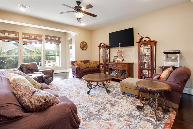 living room featuring ceiling fan and dark hardwood / wood-style flooring