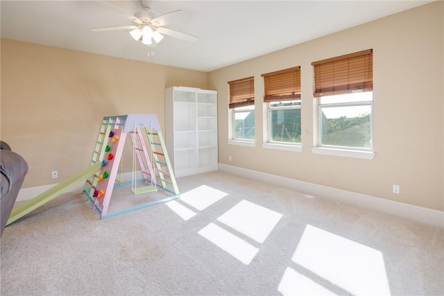 interior space with light carpet and ceiling fan