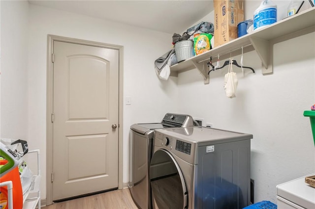 washroom with light hardwood / wood-style floors and washing machine and clothes dryer