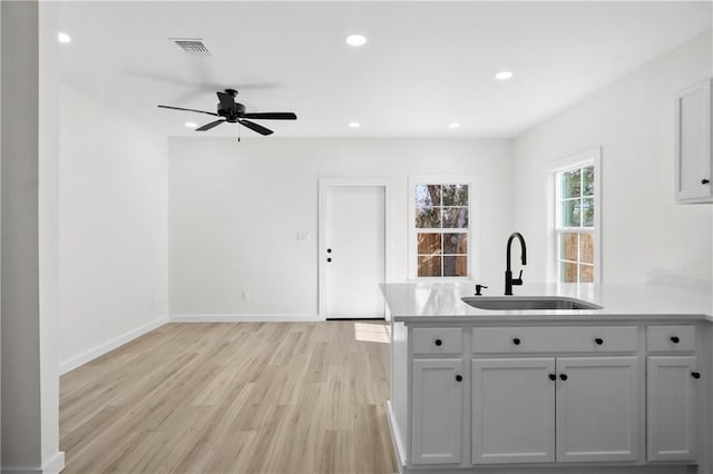 kitchen with ceiling fan, sink, gray cabinetry, and light wood-type flooring