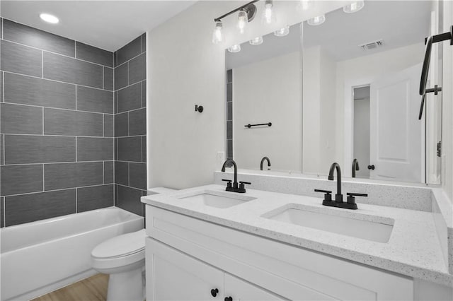 full bathroom with wood-type flooring, vanity, toilet, and tiled shower / bath