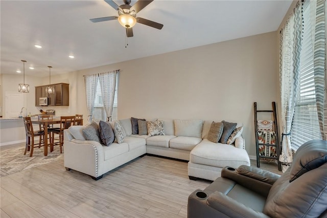 living room with ceiling fan and light wood-type flooring