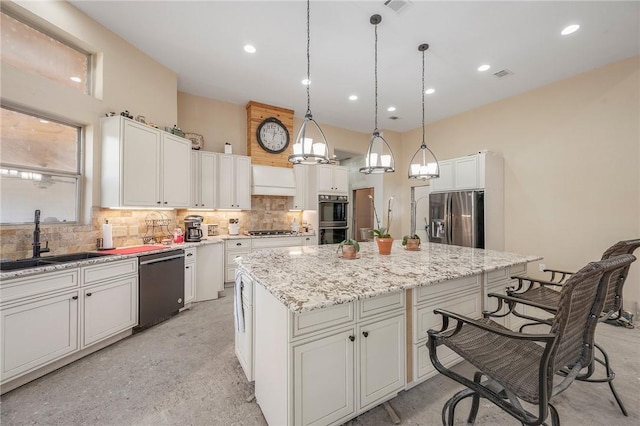 kitchen featuring a kitchen island, a breakfast bar, sink, stainless steel appliances, and white cabinets