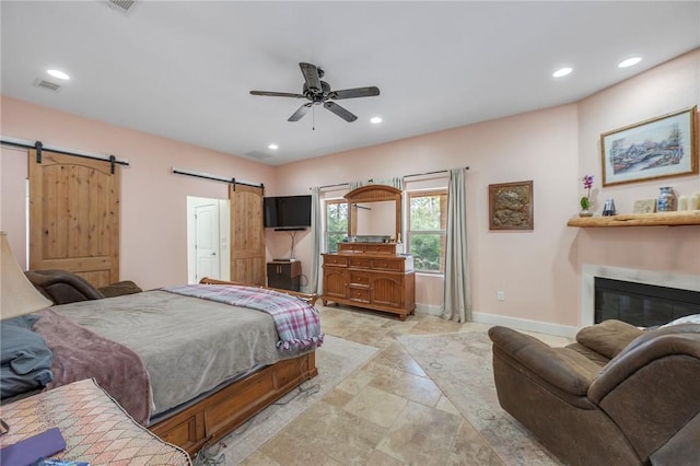 bedroom featuring ceiling fan and a barn door