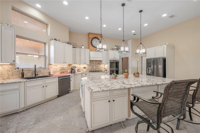 kitchen featuring appliances with stainless steel finishes, white cabinets, a kitchen island, and sink