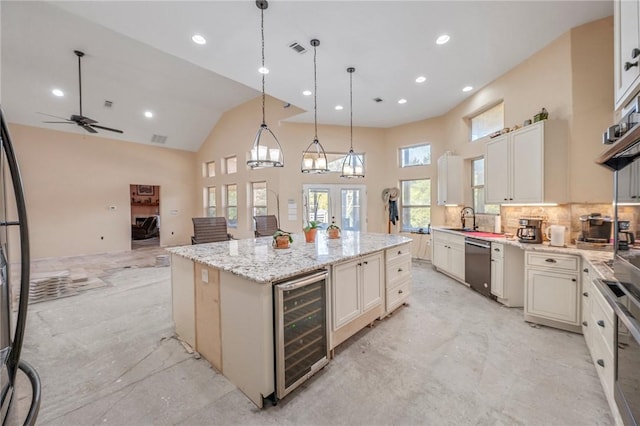 kitchen featuring ceiling fan, wine cooler, hanging light fixtures, stainless steel dishwasher, and a center island