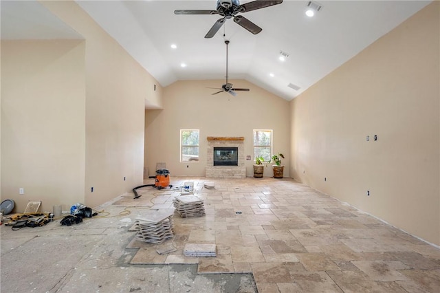 unfurnished living room featuring high vaulted ceiling and ceiling fan