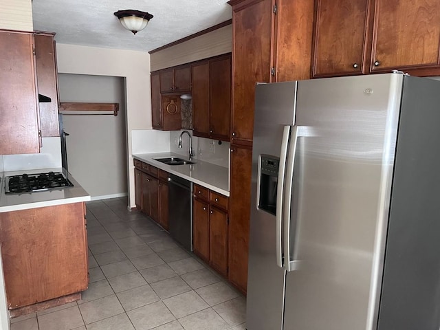 kitchen featuring gas cooktop, stainless steel fridge, sink, light tile patterned floors, and dishwasher