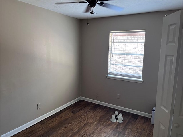 unfurnished room with ceiling fan and dark hardwood / wood-style flooring