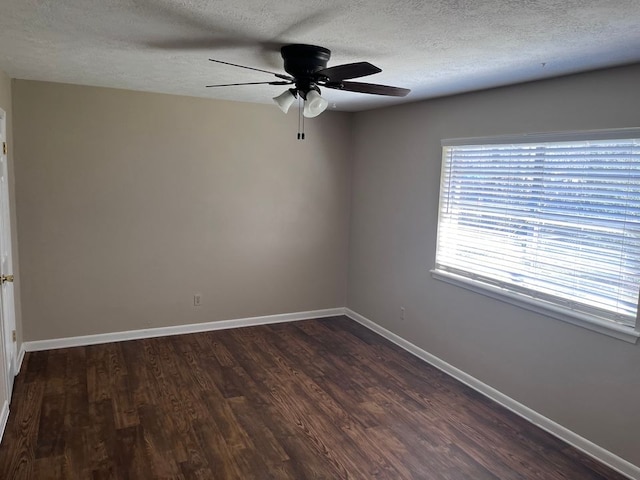 spare room with a textured ceiling, ceiling fan, and dark hardwood / wood-style floors