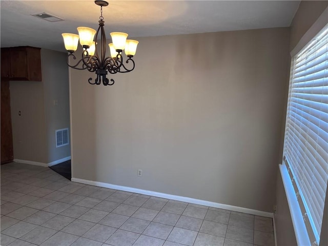 spare room with light tile patterned floors and a notable chandelier