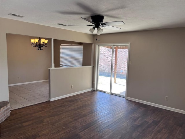 unfurnished room with a textured ceiling, dark hardwood / wood-style flooring, and ceiling fan with notable chandelier