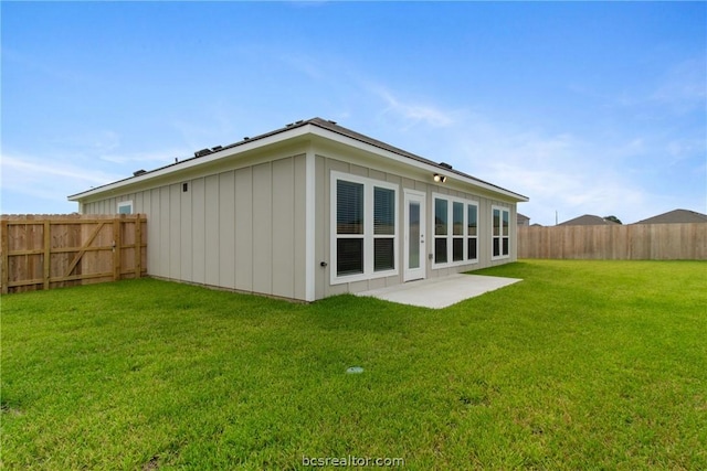 back of house with a patio area and a lawn