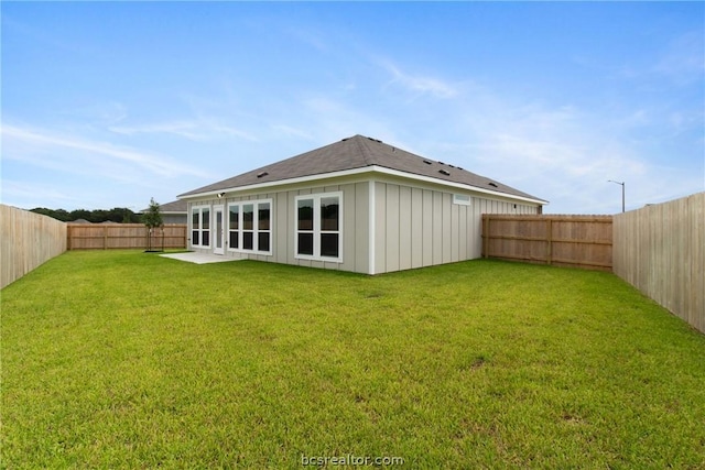 rear view of property with a lawn