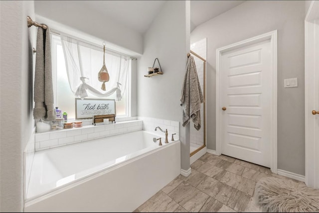 full bath with a shower stall, a bath, and baseboards