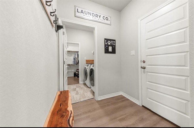 laundry room with washer and dryer, wood finished floors, and baseboards