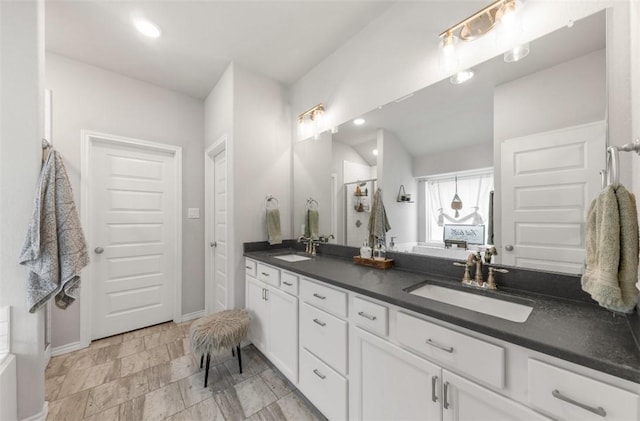 full bath featuring double vanity and baseboards