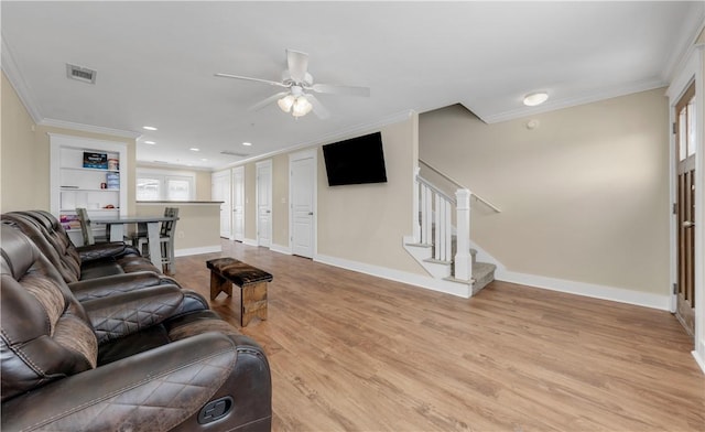 living room featuring visible vents, stairs, light wood-style floors, and ornamental molding