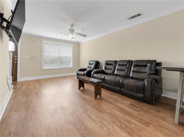 living area featuring ceiling fan, visible vents, ornamental molding, and light wood-style flooring