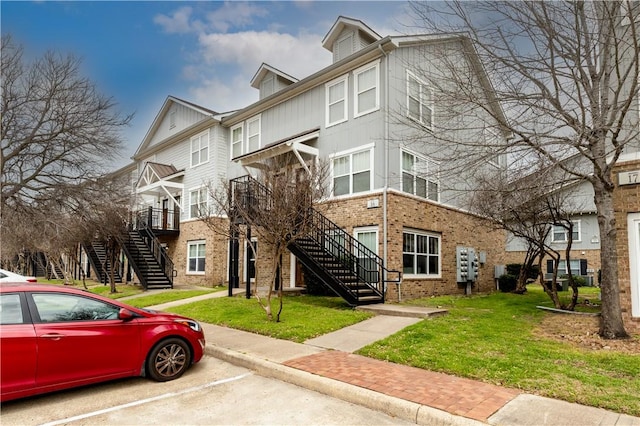 view of property with stairway and uncovered parking