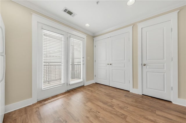 unfurnished bedroom with visible vents, access to exterior, light wood-style flooring, and ornamental molding