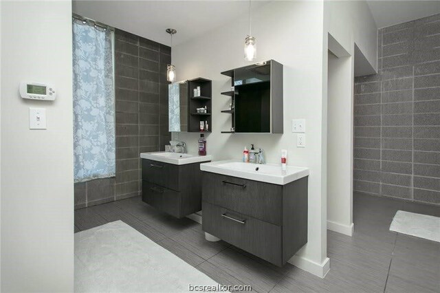 bathroom with tile patterned floors, vanity, and tile walls