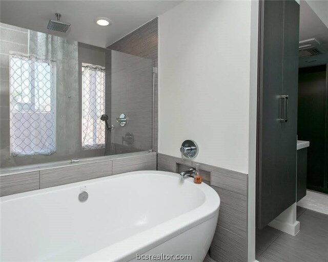 bathroom featuring tile patterned floors and plus walk in shower