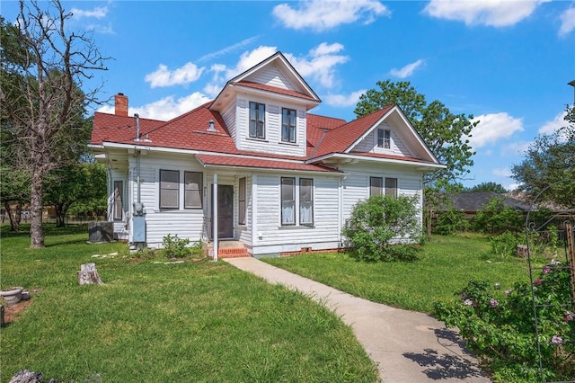 view of front of house featuring a front lawn and a chimney