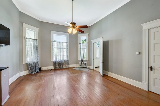 interior space with hardwood / wood-style floors, a ceiling fan, baseboards, and ornamental molding