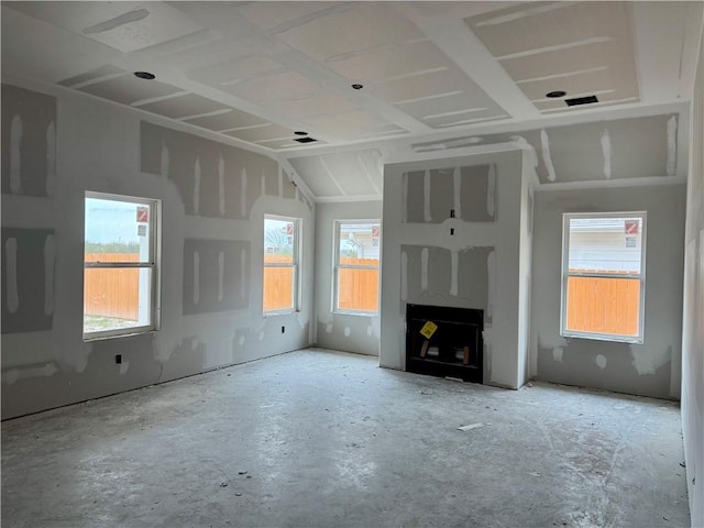 unfurnished living room with a fireplace, plenty of natural light, and vaulted ceiling