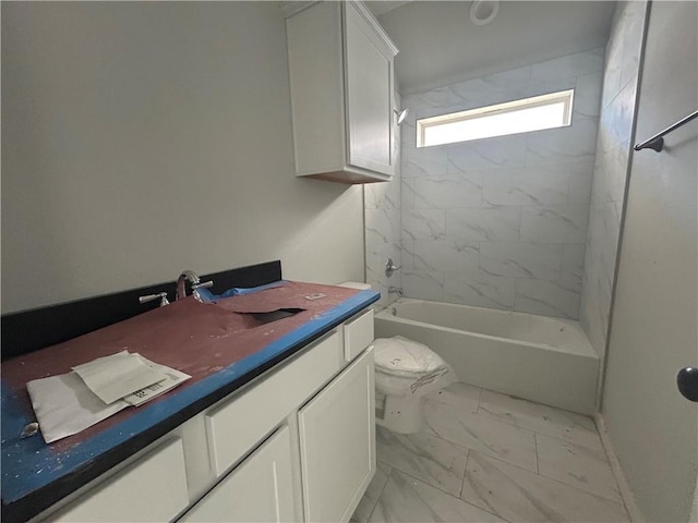 bathroom featuring marble finish floor, vanity, toilet, and bathing tub / shower combination